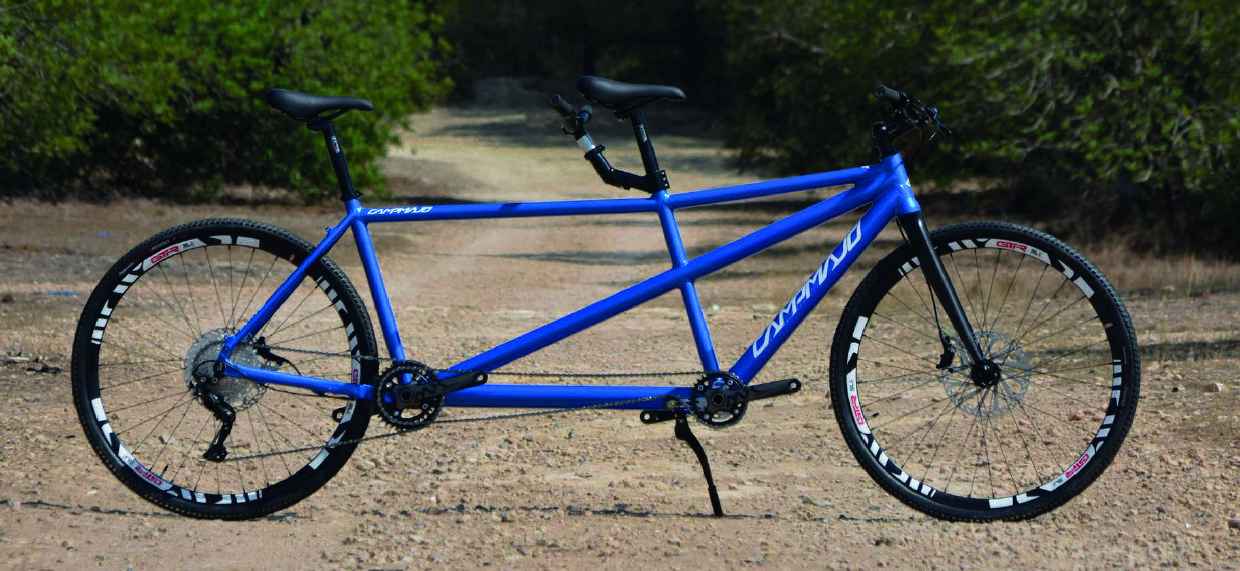 Two adventurers set off on their Gravel Tandem Bike, showcasing the partnership and excitement to tackle gravel paths together